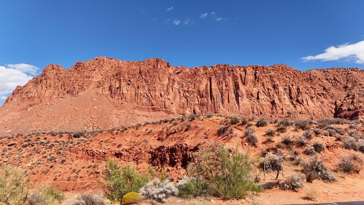 Red sandstone cliff wall and desert brush near Ivins, Utah