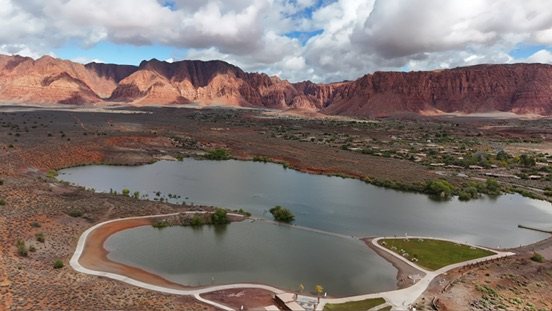 Aerial view of a reservoir below red cliffs in Southern Utah